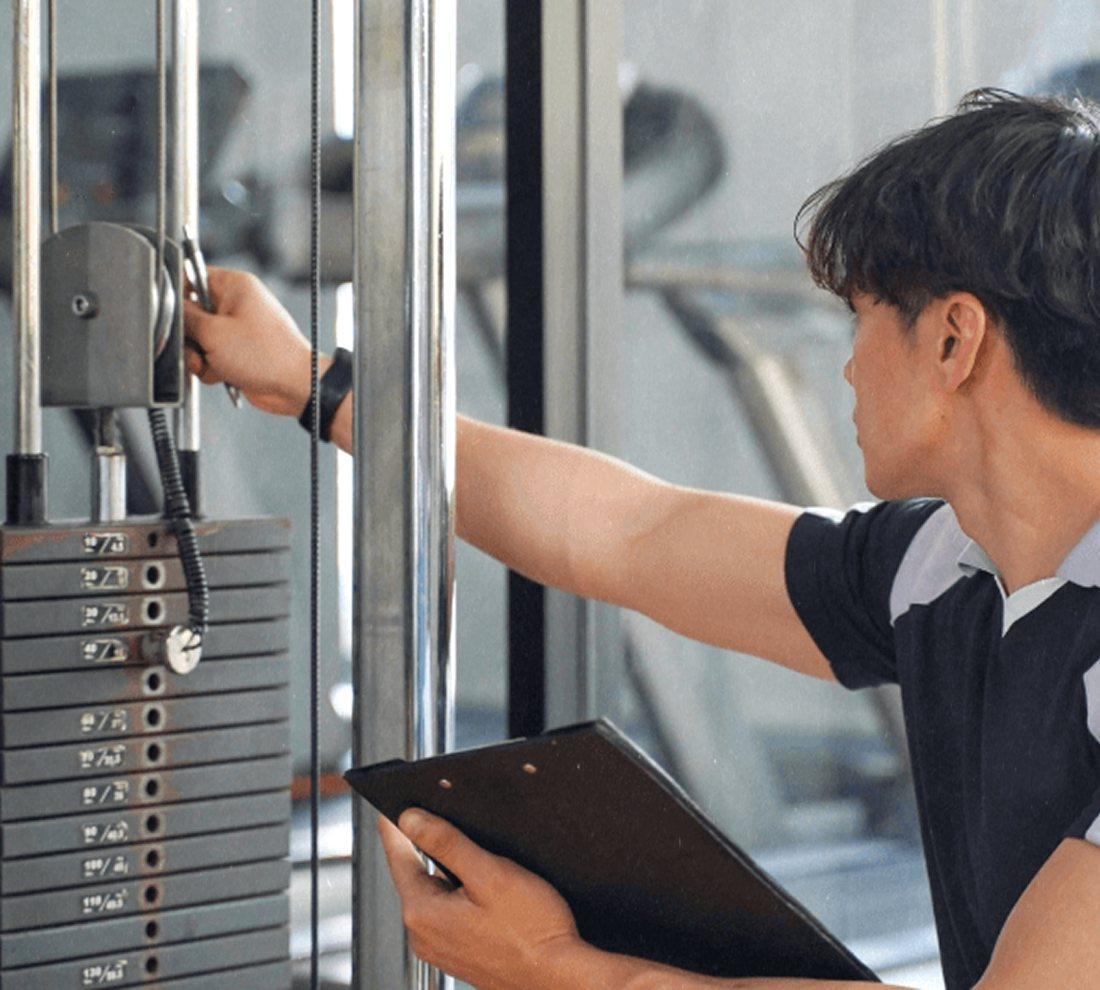 Technicien contrôlant une machine de musculation