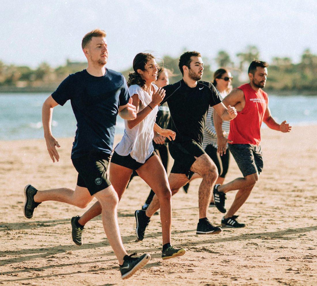 Groupe courant sur la plage lors d'une journée sport et bien-être